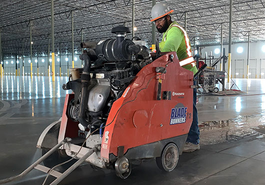 Equipment operator Jerry Barragan performs saw cuts for structural footings in a tilt-up warehouse building. 